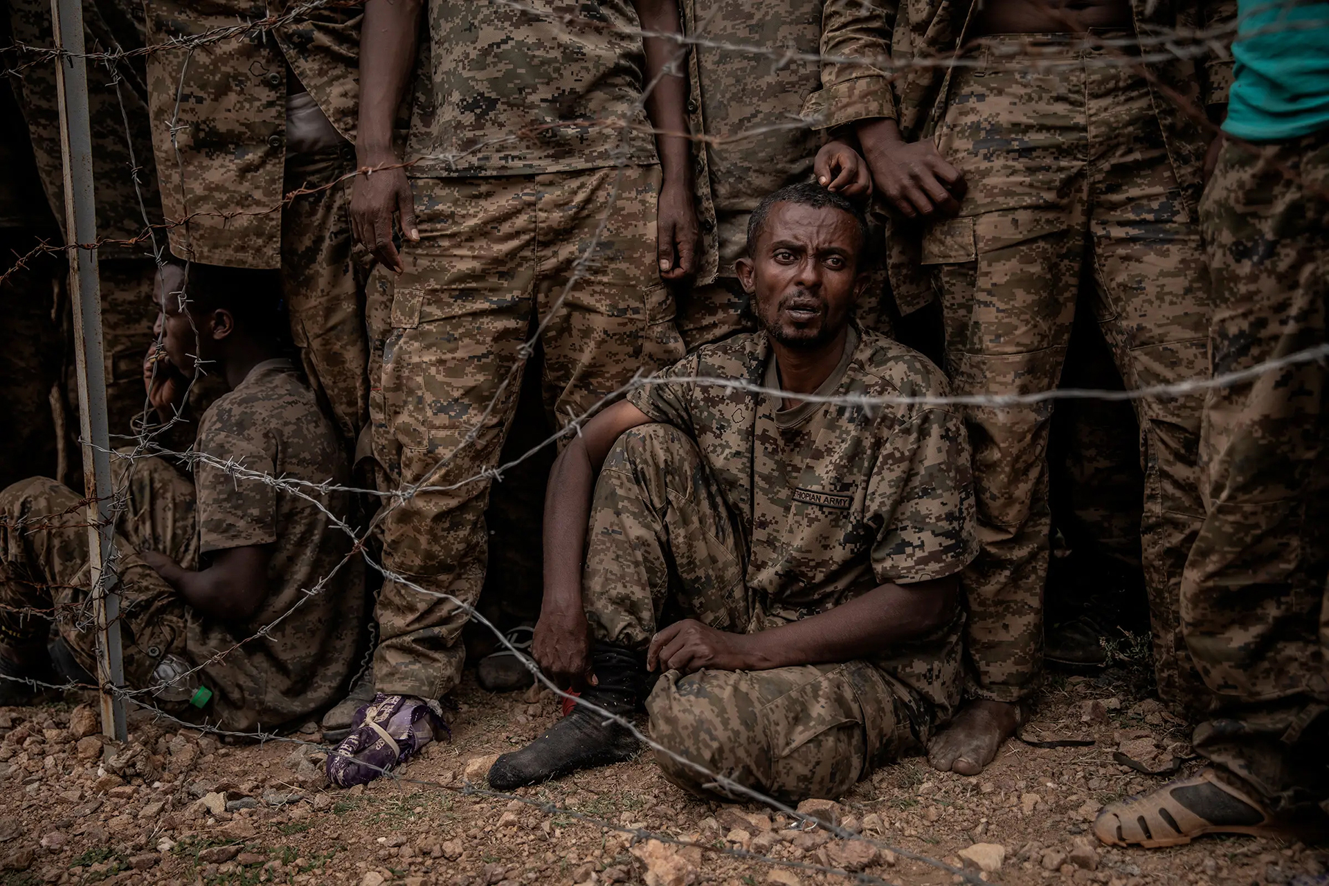 Captured Ethiopian government soldiers at a prisoner-of-war camp in the mountains of Tigray in June 2021. Some 6,000 government troops were captured by the Tigray People's Liberation Front during fighting in Ethiopia's northern Tigray region. Fighting broke out in Tigray in November 2020 when the government accused the TPLF of attacking military bases across the region, which the party denied. The civil war has drawn in neighboring Eritrea on the side of the Ethiopian government and has been marked by atrocities, starvation, and allegations of war crimes by both sides. The government declared victory three weeks into the conflict when it took control of the regional capital Mekelle, but the Tigrayan guerrilla army known as the Tigray Defense Forces (TDF) retook Mekelle and most of Tigray at the end of June, after the government suffered a cascade of battlefield loses. Thousands of people have died in the fighting; around 2 million have been displaced and more than 5 million rely on food aid.  © Finbarr O’Reilly / VII.